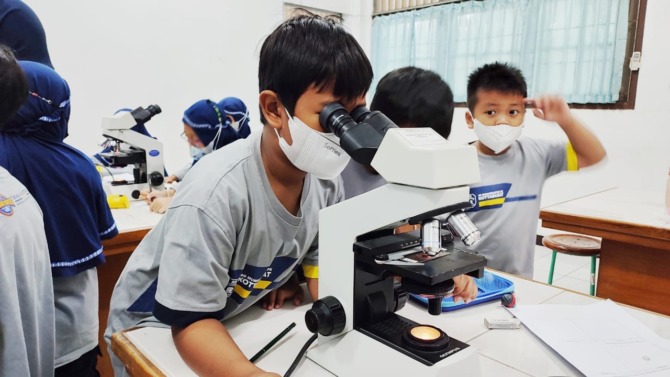 TERPUKAU: Siswa SD Muhammadiyah Program Khusus Kottabarat Surakarta melakukan pembelajaran menggunakan mikroskop binokuler di Laboratorium FKIP Biologi UMS, Sabtu (21/1). (SEPTIAN REFVINDA ARGIANDINI/RADAR SOLO)