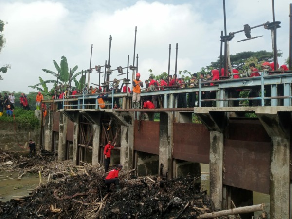 Kelompok relawan di Sukoharjo bersama relawan PDI Perjuangan bersihkan sampah di Bendungan Siliwur, Sabtu (28/1/2023). Desain bendungan di Desa Tegalsari, Kecamatan Weru ini akan dirombak karena dinilai hambat aliran sungai. (IWAN KAWUL/RADAR SOLO)