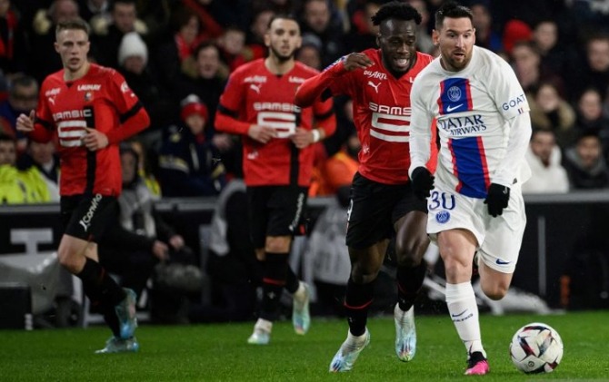 Pemain PSG Lionel Messi (kanan) ditempel penyerang Rennes Arnaud Kalimuendo saat menggiring bola dalam pertandingan Liga Prancis di Roazhon Park stadium, Rennes pada Senin (16/1) dini hari WIB. (ANTARA/AFP/LOIC VENANCE)