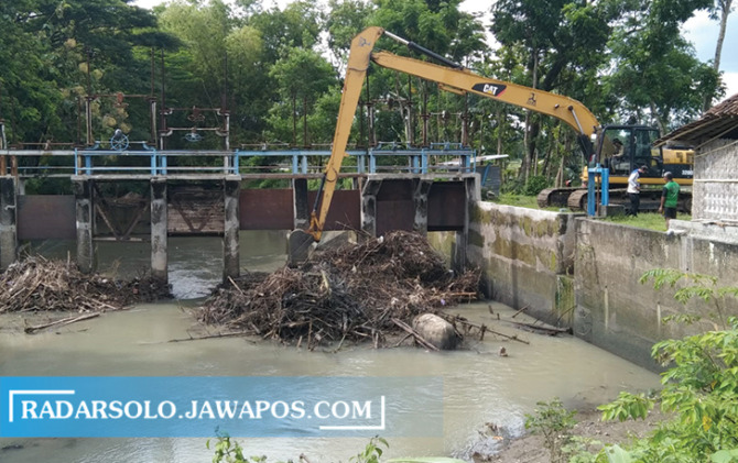 NORMALISASI: Alat berat bersihkan sampah di Bendung Siluwur. (IWAN KAWUL/RADAR SOLO)