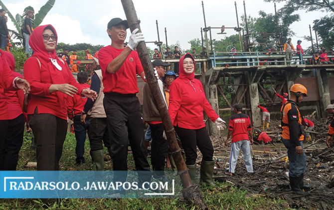 TERSUMBAT: Bupati Sukoharjo Etik Suryani (tiga dari kiri) dan Ketua DPRD Sukoharjo Wawan Pribadi (dua dari kiri) turun langsung pimpin bersih-bersih Bendungan Siluwur, Weru, Sabtu (29/1/2023). (IWAN KAWUL/RADAR SOLO)