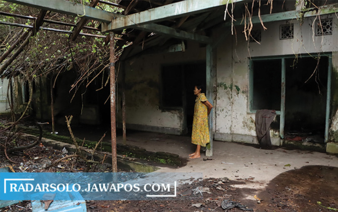 MEMPRIHATINKAN: Sukiyem menunjukkan kondisi di dalam eks RS Kadipolo yang tidak terurus dan banyak dipenuhi semak belukar dan pepohonan yang tumbuh lebat di dalamnya, Minggu (22/1/2023). (M. IHSAN/RADAR SOLO)
