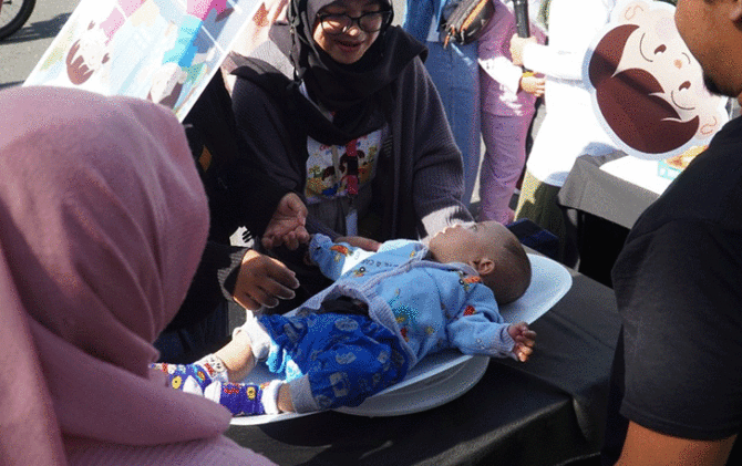 Masyarakat antusias mengikuti pengukuran gratis bagi bayi dan balita yang digelar PT Solo Abadi Indonesia pada car free day (CFD) di Jalan Slamet Riyadi Solo, Minggu (15/1).  