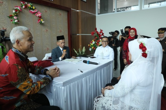SAKSI NIKAH: Gubernur Ganjar Pranowo dan Menpan-RB Abdullah Azwar Anas menjadi saksi pernikahan warga di Balai Nikah Mal Pelayanan Publik (MPP) Sragen, Senin (20/2/2023). (ISTIMEWA)