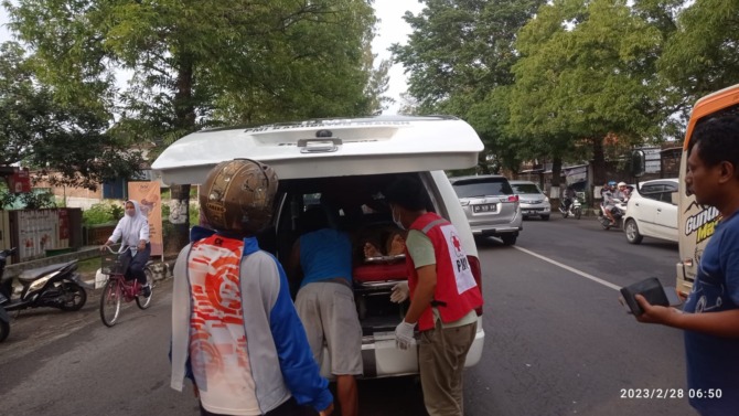 NAHAS: Relawan PMI Sragen mengevakuasi jasad kakek yang kecelakaan di Jalan Raya Sukowati, Sragen, Selasa (28/2/2023). (AHMAD KHAIRUDIN/RADAR SOLO)