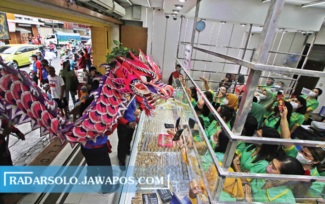 Barongsai dan Liong beraksi di salah satu toko di kawasan Pasar Gede dalam perayaan Cap Go Meh, Sabtu (5/2/2023). (ARIEF BUDIMAN/RADAR SOLO)