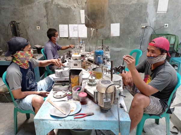 Perajin di Giriwoyo menghaluskan batu obsian yang dibentuk menjadi beragam perhiasan, Selasa (21/2/2023). (IWAN ADI LUHUNG/RADAR SOLO)