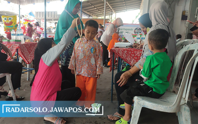 HARUS RUTIN: Siswa TK mengikuti pengukuran tinggi badan saat posyandu. (AHMAD KHAIRUDIN/RADAR SOLO)