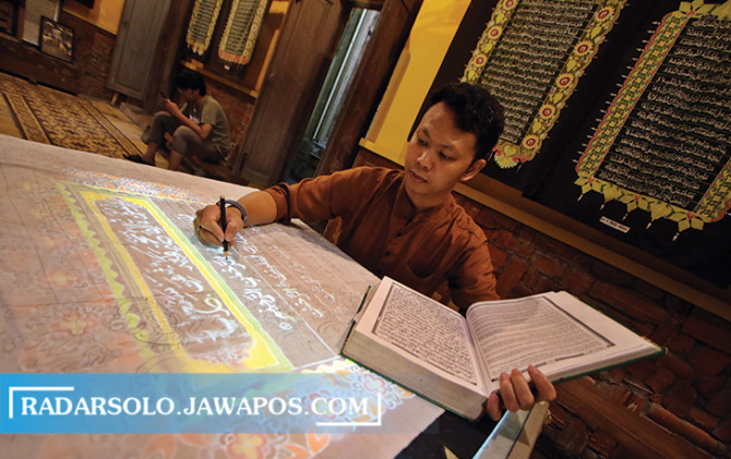 UNIK: Ahli kaligrafi menuliskan huruf arab di atas kain di salah satu rumah produksi batik Laweyan kemarin. (ARIEF BUDIMAN/RADAR SOLO)