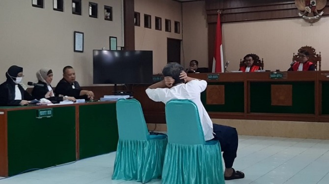 Bambang Tri Mulyono, terdakwa kasus ujaran kebencian ijazah palsu Presiden Jokowi menutup telinga saat jaksa penuntut umum membacakan tuntutan pada sidang di Pengadilan Negeri (PN) Surakarta, Selasa (21/3/2023). (ANTONIUS CHRISTIAN/RADAR SOLO)