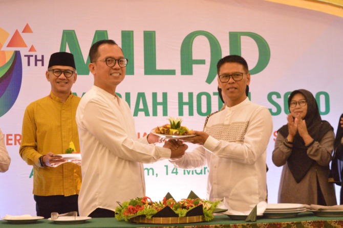 SIMBOLIS: Penyerahan tumpeng dari general manager Heri Haryosa kepada executive assistant manager Joko Susilo saat perayaan milad ke-9 tahun Syariah Hotel Solo di Ar Raihan Ballroom hotel setempat, Selasa (14/3/2023). (SEPTINA FADIA PUTRI/RADAR SOLO)