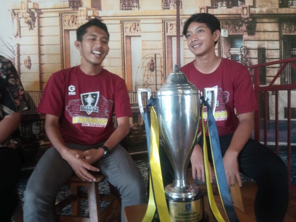 Pelatih kesebelasan U-15 Sukoharjo M. Khoirullah (kiri) dan kapten kesebelasan M. Reyhan pamerkan trofi Piala Soeratin, Jumat (3/3/2023). (IWAN KAWUL/RADAR SOLO),
