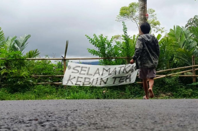 Spanduk kritikan yang dipasang warga Desa Kemuning dan Desa Segorogunung, Kecamatan Ngargoyoso pasca adanya pengerukan tanah di kawasan kebun teh Kemuning. (RUDI HARTONO/RADAR SOLO)