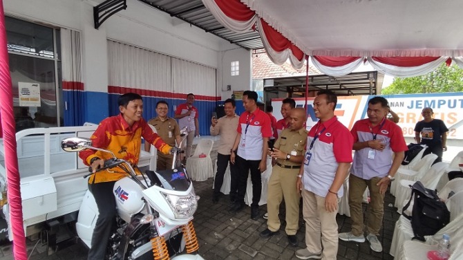 Wahyudi menjajal kendaraan roda tiga yang merupakan CSR JNE kepada Rumah Baca  Sang Petualang di JNE Wonogiri, Selasa (21/3/2023). (IWAN ADI LUHUNG/RADAR SOLO)