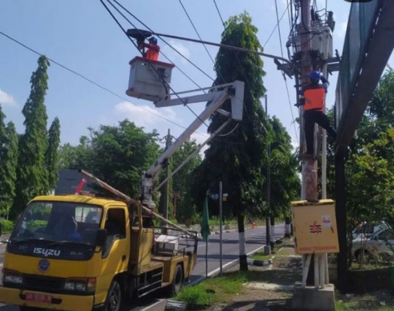 ILUSTRASI: Petugas Dishub tengah memperbaiki LPJU di Jalan Jenderal Sudirman, Sukoharjo. (IWAN KAWUL/RADAR SOLO)