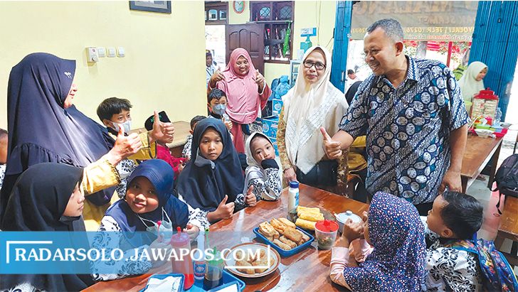 TETAP EKSIS: Pemilik Bakso Malang Pak Slamet, Slamet, dan sang istri, Sutini menyambut anak yatim piatu yang ikut makan bersama dalam rangka 36 tahun warung ini berdiri. (RAGIL LISTYO/RADAR SOLO)