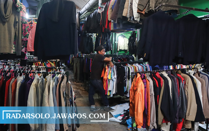 Pedagang pakaian bekas impor di Semanggi, Solo. Mereka mengaku tak terpengaruh dengan ancaman pemerintah menindak thrifting karena melanggar regulasi. (M. IHSAN/RADAR SOLO)