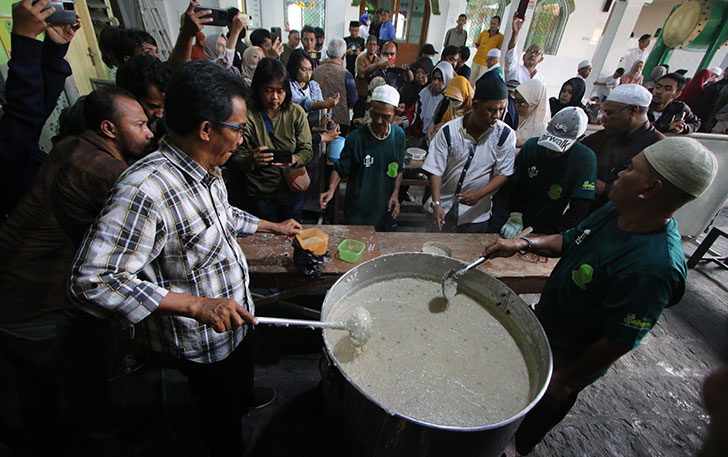 Masyarakat mengantre bubur samin yang dibagikan di Masjid Darussalam Jayengan, Solo, Kamis (23/3). (ARIEF BUDIMAN/RADAR SOLO)