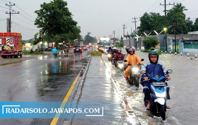 PICU KEMACETAN: Kondisi jalan Solo-Sragen di Desa Waru, Kecamatan Kebakkramat, Karanganyar yang terendam banjir, Kamis (2/3/2023). (RUDI HARTONO/RADAR SOLO)