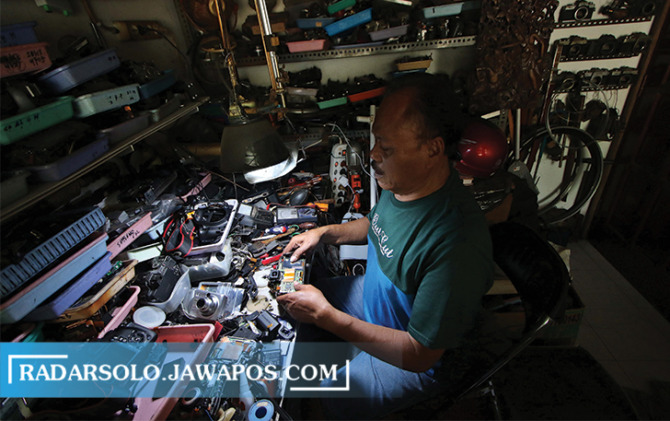 PEKERJA KERAS: Kasiman sedang memperbaiki kamera di tokonya kemarin. (ARIEF BUDIMAN/RADAR SOLO)