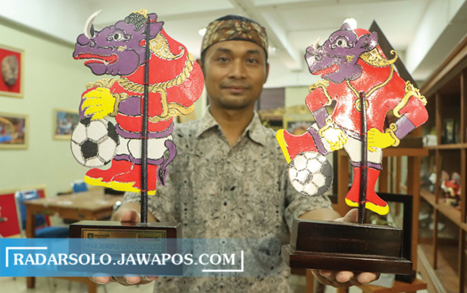 TERKENA IMBAS: Margono memperlihatkan sampel suvenir bergambar badak bercula satu dan Rajamala untuk Piala Dunia U-20 di Solo. (M. IHSAN/RADAR SOLO)