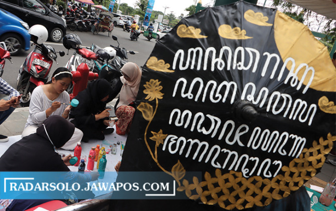TAK LEKANG ZAMAN: Payung karya Putri Listyandari yang dihiasai dengan aksara Jawa. (M. IHSAN/RADAR SOLO)