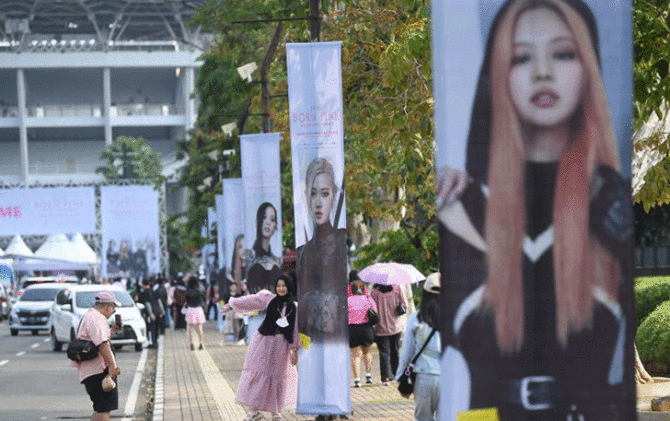 Penggemar Blackpink berfoto di depan poster sebelum berlangsungnya konser di Jakarta, Sabtu (11/3/2023). (ANTARA/Akbar Nugroho Gumay)