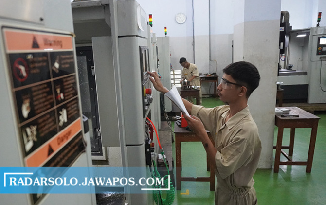 TERLATIH: Siswa SMK Warga mengikuti uji kompetensi keahlian yang melibatkan industri dengan mengoperasikan mesin CNC milling, Rabu (15/3/2023). (TRI WAHYU CAHYONO/RADAR SOLO)
