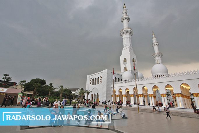 MAGNET WISATA: Pengunjung menikmati keindahan Masjid Sheikh Zayed sembari menunggu buka puasa Senin (27/3/2023). Kehadiran masjid ini menjadi salah satu daya tarik wisatawan pada Ramadan ini. (ARIEF BUDIMAN/RADAR SOLO)