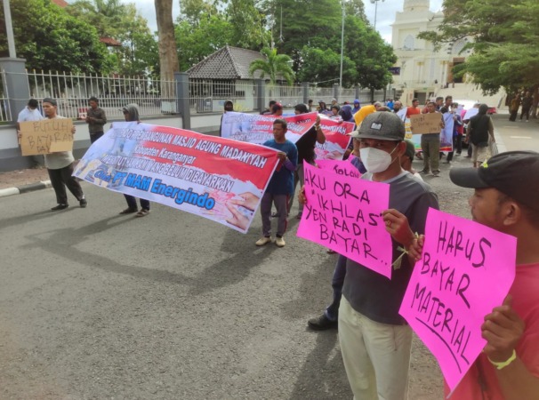 AKSI DAMAI: Sejumlah orang perwakilan vendor proyek Masjid Agung Madaniyah menggelar unjuk rasa dengan membawa spanduk di depan kantor bupati Karanganyar, Jumat siang (14/4/2023). (RUDI HARTONO/RADAR SOLO)