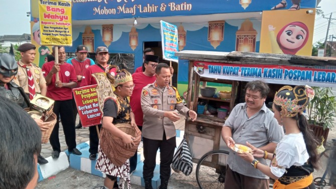 UCAPAN TERIMAKASIH: Gatotkaca membuat aksi dengan memberikan kupat tahu kepada Kapolres Sukoharjo AKBP Wahyu Nugroho Setyawan atas kelancaran arus mudik dan balik di momen Lebaran. (IWAN KAWUL/RADAR SOLO)