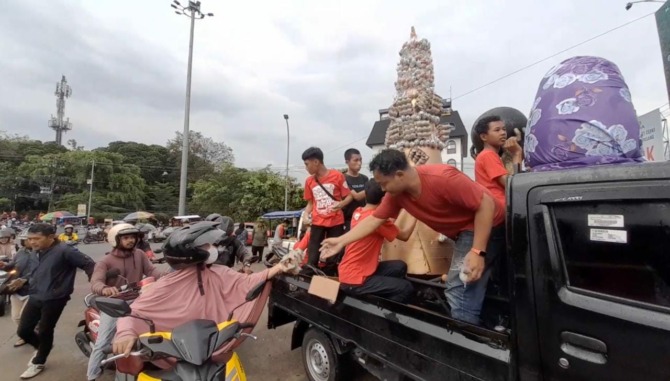 Pembagian telur paskah dan takjjil kepada warga yang melintas di Simpang Lima Boyolali, Sabtu (8/4/2023). (RAGIL LISTIYO/RADAR SOLO)