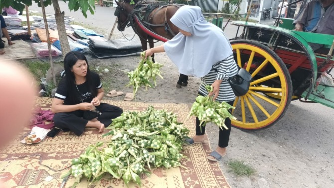Penjual selongsong ketupat di pasar tradisional Pengging, Banyudono, Boyolali, layani pembeli, Jumat (28/4/2023). (RAGIL LISTIYO/RADAR SOLO)