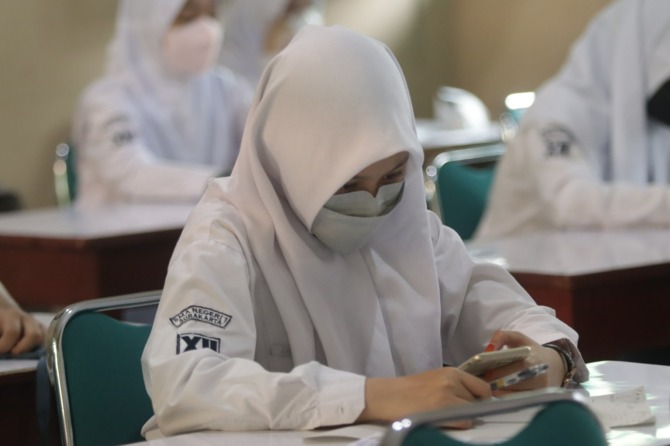 FOKUS: Salah seorang siswa di SMAN 1 Surakarta tengah menjalani pembelajaran lewat gadget saat masa pandemi Covid-19. (M. IHSAN/RADAR SOLO)