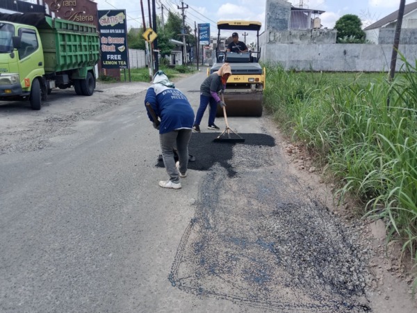 DIASPAL: Sejumlah pekerja menambal jalan berlubang di Sukoharjo dengan aspal, Senin (17/4/2023). (IWAN KAWUL/RADAR SOLO)