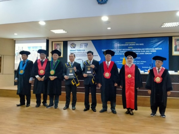 Penyerahan sertifikat kelulusan oleh Wakil Rektor I UMS Prof Harun Joko Prayitno kepada dua doctor baru Ilmu Hukum yakni Sekda Rembang Fahrudin dan Rifqi Ridlo Phahlevy di gedung pascasarjana UMS, Kamis (25/5). (SEPTIAN REVFINDA/RADAR SOLO)   
