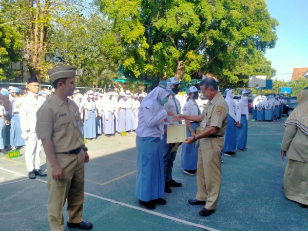 SIMBOLIS: Plt Kepala SMAN 1 Surakarta Sukamto (kanan) memberikan piagam kepada siswa berprestasi, Senin (15/5/2023). (SEPTIAN REFVINDA/RADAR SOLO)