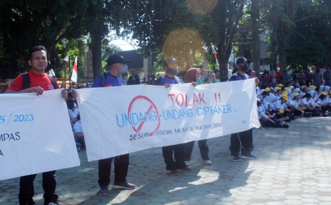 RELA PANAS-PANASAN: Ribuan pekerja menggelar aksi damai sambil membentangkan spanduk saat May Day atau Hari Buruh di Alun-Alun Satya Negara Sukoharjo, Senin (1/5/2023). (IWAN KAWUL/RADAR SOLO)