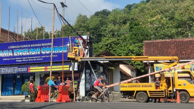 Petugas Dishub Wonogiri melakukan penanganan di traffic light Metro yang tertabrak Minggu (7/5/2023). (IWAN ADI LUHUNG/RADAR SOLO)