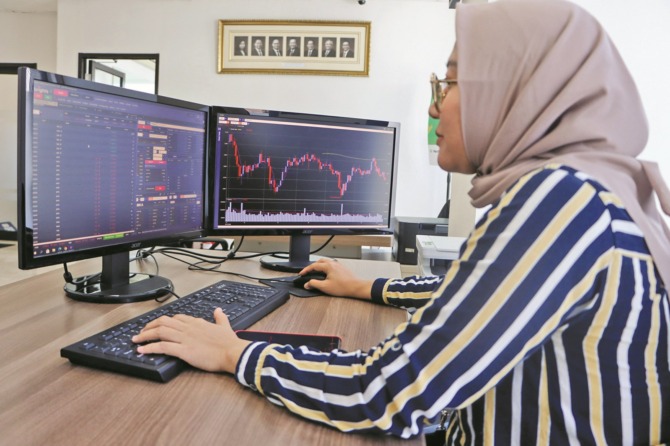 AMAN: Investor mengamati pergerakan pasar modal di Bursa Efek Indonesia (BEI) Solo, kemarin (12/5). Keamanan pasar modal sudah dijamin oleh SIPF. (M. IHSAN/RADAR SOLO)