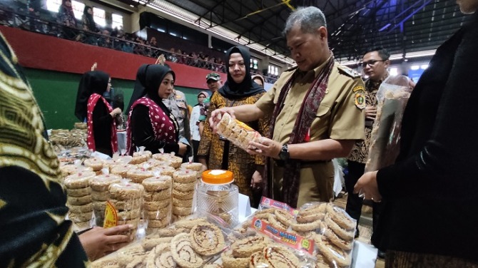 Pimpinan Cabang PT PNM Wonogiri Setiyo Prihartaeni mendampingi Wakil Bupati Wonogiri Setyo Sukarno mengecek produk displai saat PKU Akbar di GOR Giri Mandala Wonogiri Selasa (9/5). (IWAN ADI LUHUNG/RADAR SOLO)