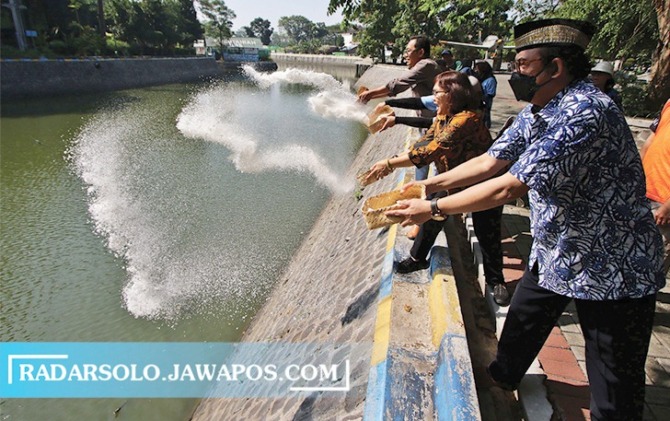PEDULI LINGKUNGAN: Pakar lingkungan kampus dan mahasiswa saat melakukan penjernihan air danau kampus UNS dengan penaburan tawas, Rabu (31/5/2023). (ARIEF BUDIMAN/RADAR SOLO)
