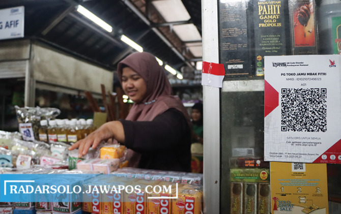 PRAKTIS: Pembeli dan penjual di Pasar Gede bisa bertransaksi menggunakan QRIS. (M. IHSAN/RADAR SOLO)