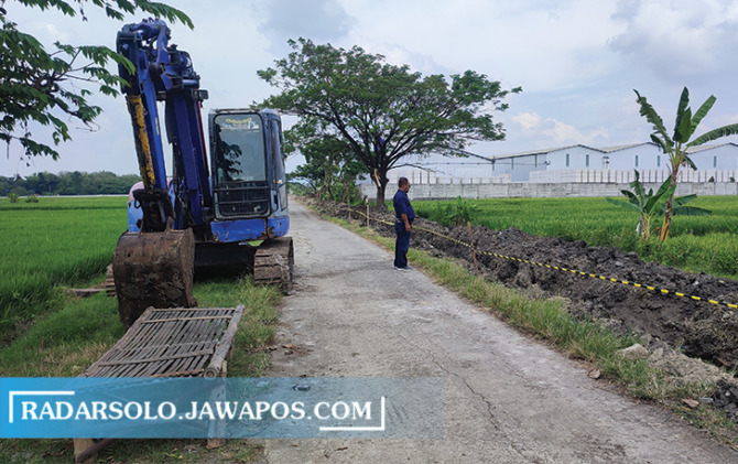 POLEMIK: Pekerjaan pengerukan tanah di jalan desa di wilayah Desa Toyogo, Sambungmancan yang akan dijadikan akses pabrik. (AHMAD KHAIRUDIN/RADAR SOLO)