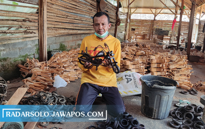 PENUH PERJUANGAN: Supadi menunjukkan miniatur Harley Davidson `yang dia buat, Rabu (3/5/2023). (IWAN ADI LUHUNG/RADAR SOLO)