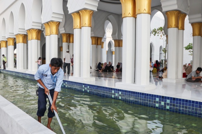 RAMAI KUNJUNGAN: Karyawan tengah membersihkan kolam di Masjid Raya Sheikh Zayed belum lama ini. (M. IHSAN/RADAR SOLO)