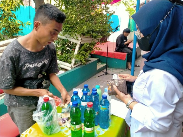 INSPIRATIF: Aan Fauzi melayani pembeli sabun cair buatannya di Colomadu kemarin. (ISTIMEWA)