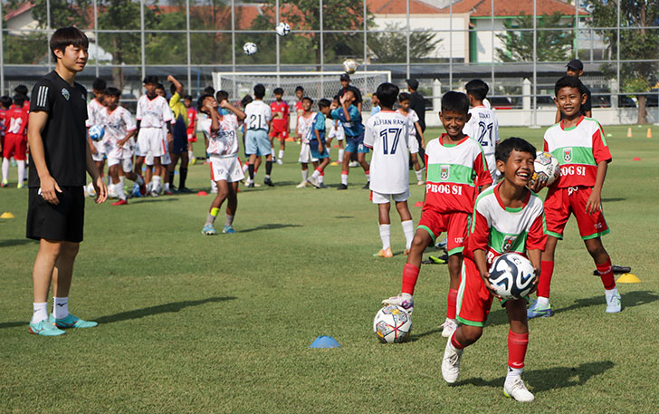 Pemain Jeonbuk Hyundai Motors berbagi ilmu dan bola kepada anak-anak SSB di Lapangan Kota Barat, Jumat (16/6). (M.IHSAN/RADAR SOLO)