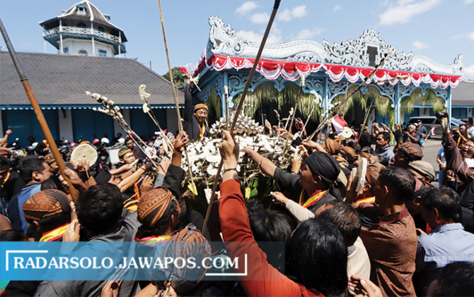 MERIAH: Para warga berebut gunungan dalam prosesi Grebeg Besar di depan Keraton Kasunanan Surakarta, kemarin. (M. IHSAN/RADAR SOLO )