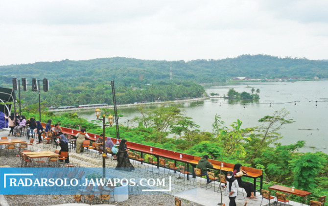 MENARIK: Wisatawan menikmati panorama Rowo Jombor dari sebuah kafe di puncak Bukit Sidoguro, Desa Krakitan, Kecamatan Bayat, Kabupaten Klaten. (ANGGA PURENDA/RADAR SOLO)